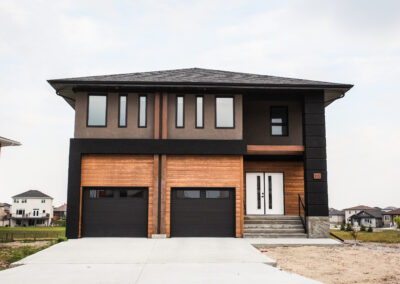 Exterior Of Home With Dark Gray And Wood Siding Built By Hillside Construction. Building Custom Homes, Cabins, and Renovations in Manitoba and Kenora.