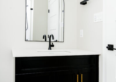 a bathroom with a black vanity and a large mirror.